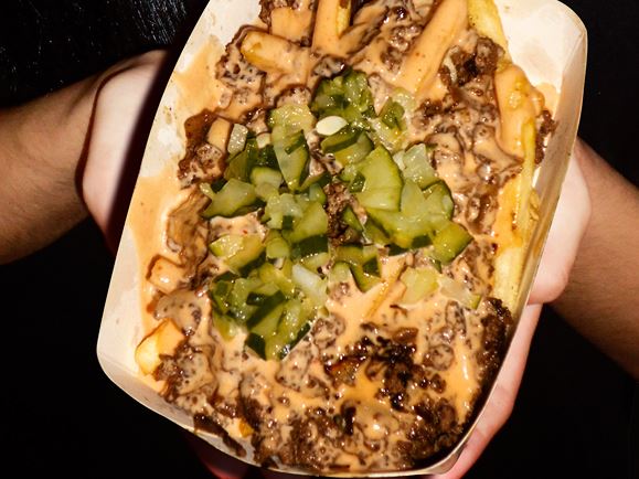 Frites loaded with cheese sauce, beef and pickles