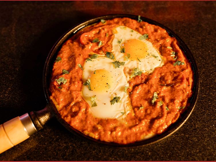 Eggs baked into a pan of spiced tomato sauce