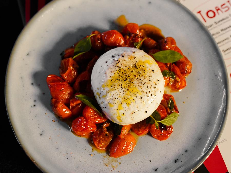 Roasted tomatoes around a ball of burrata