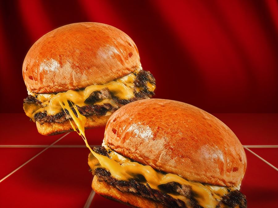 Two SMASH burgers, cheese pulling between them