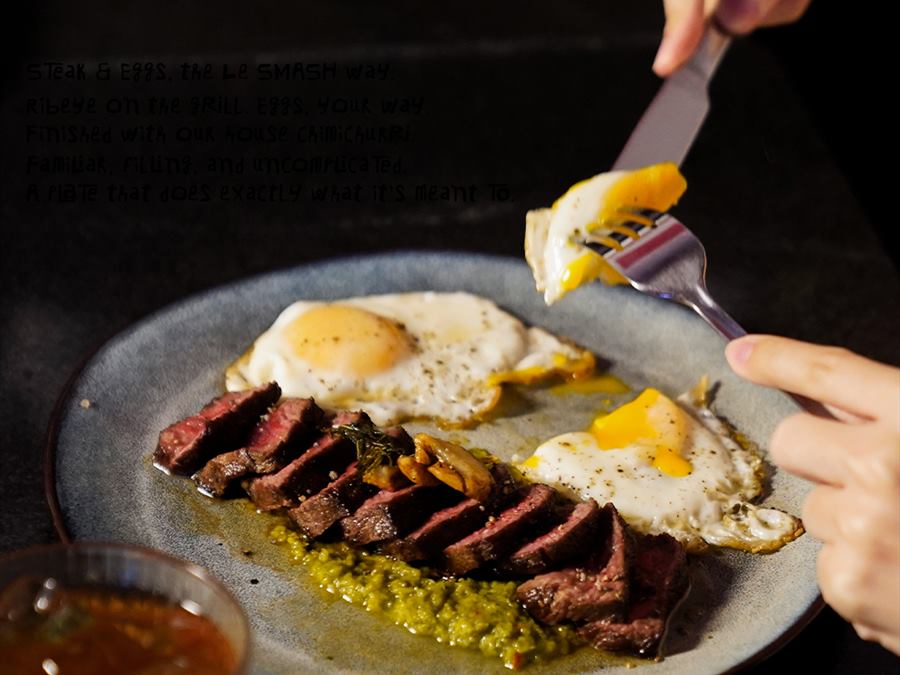 Sliced steak with fried eggs and salsa verde