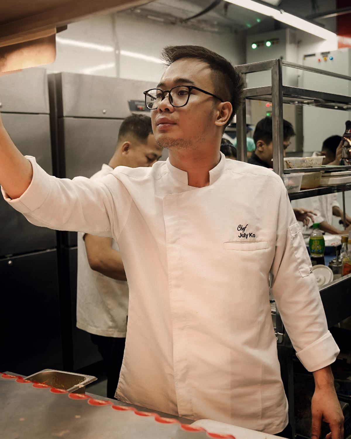A chef calling across the kitchen during service