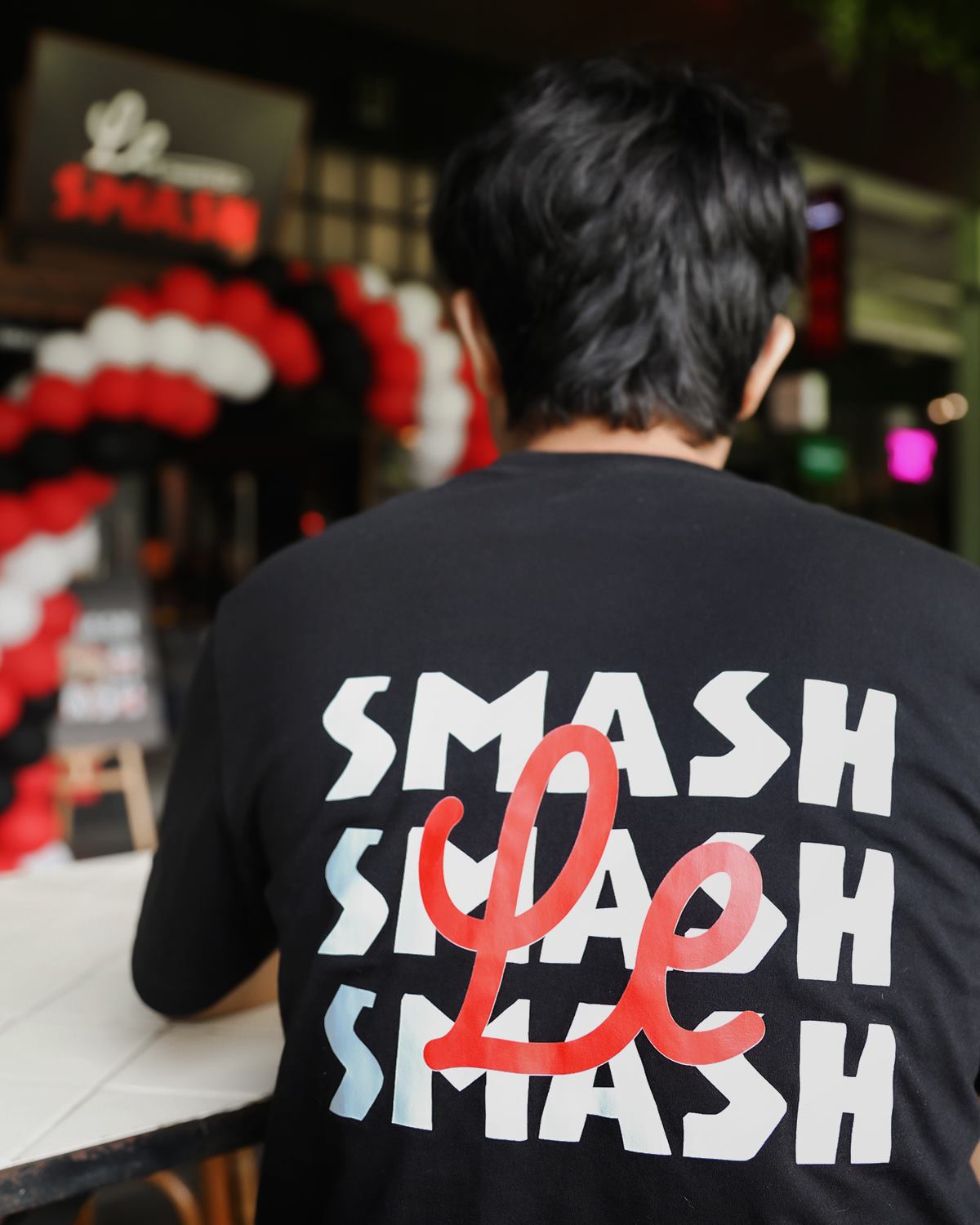 A staff shirt reading Smash, Smash, Smash from behind