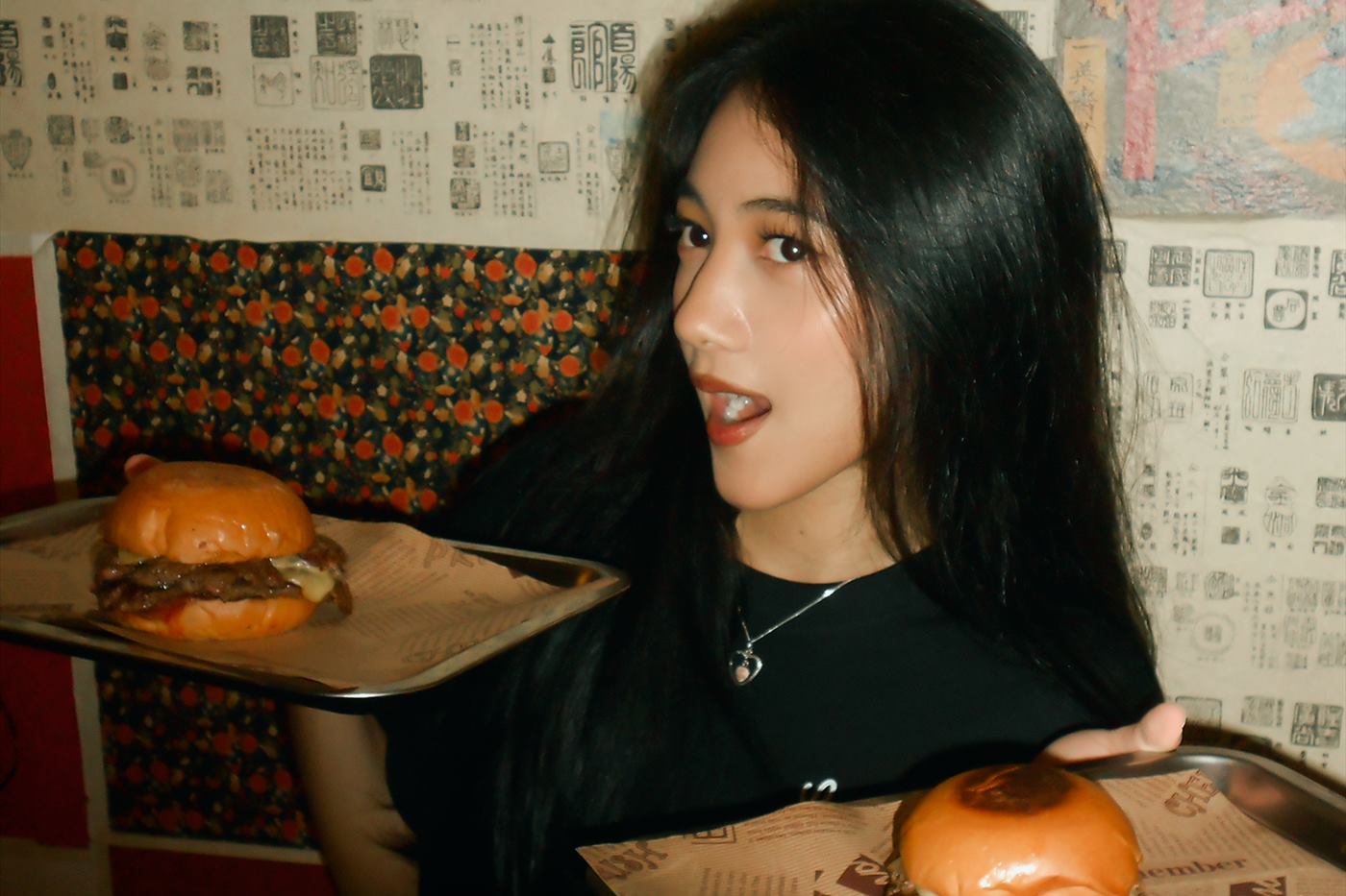 A guest carrying two trays of burgers across the room