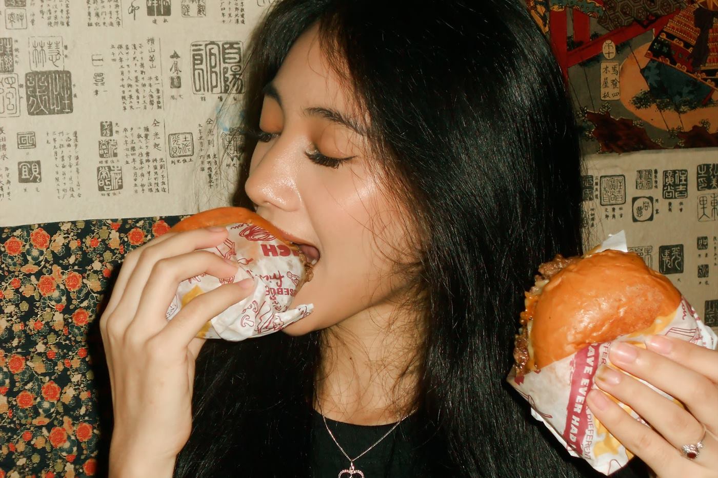 A guest mid-bite against the papered wall