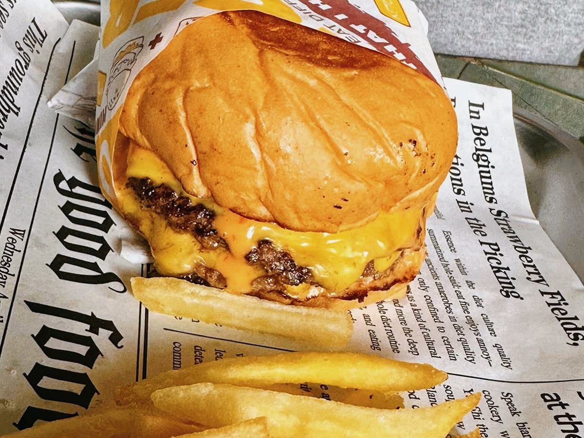 A burger and fries served on newsprint
