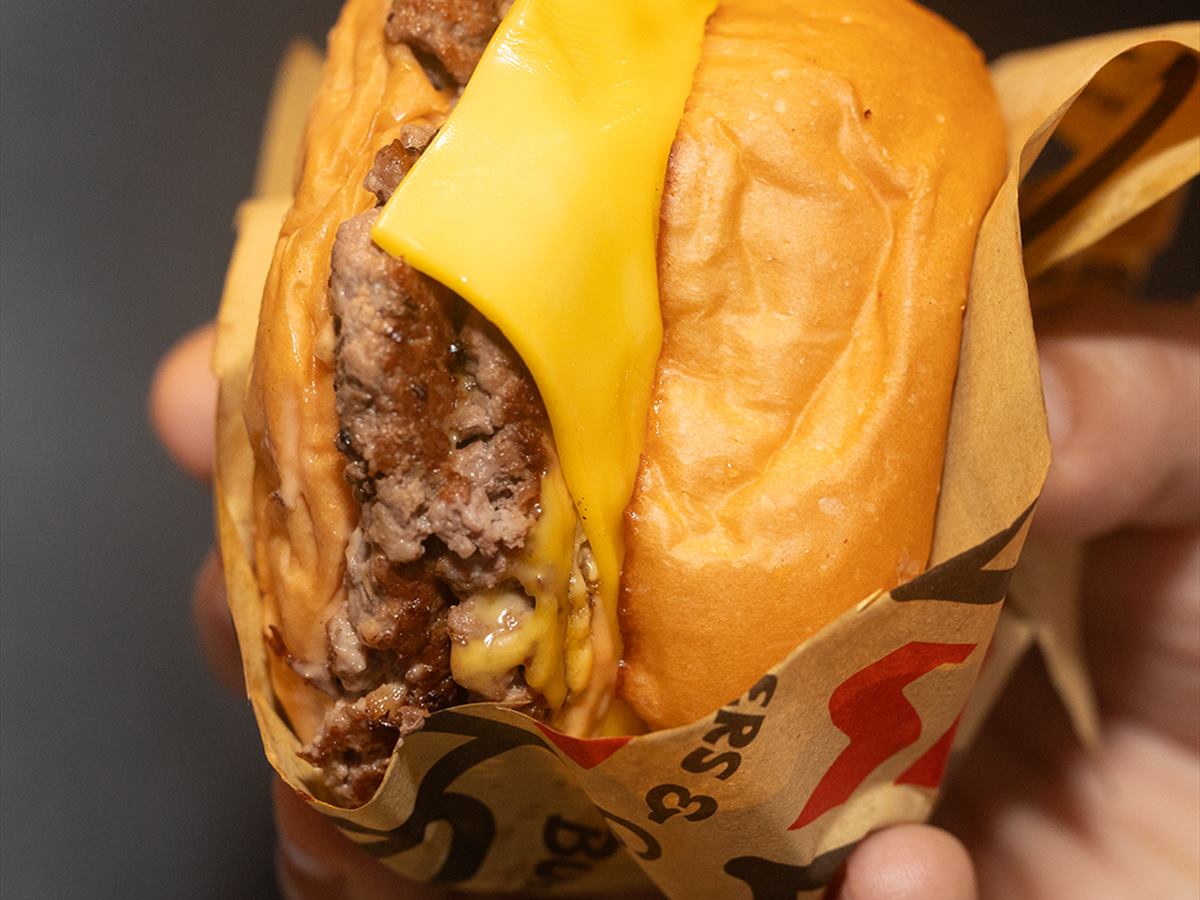 A burger half unwrapped in its printed paper