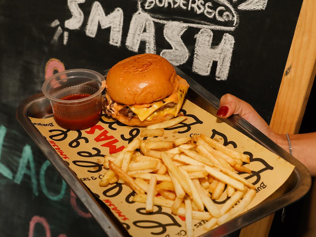 A tray of burger and fries against a chalked wall