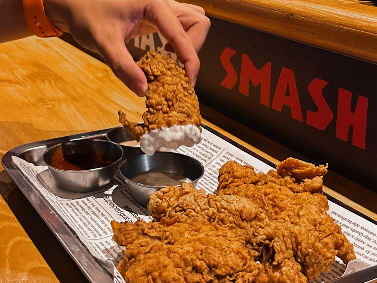 Chicken tenders and dips on a steel tray at the counter